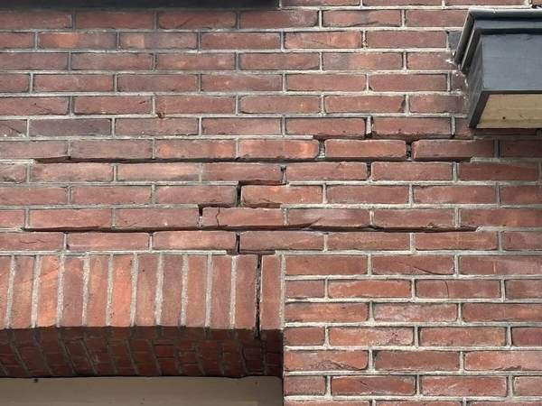 Scheur in het metselwerk boven een kozijn